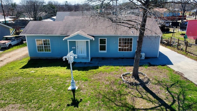 view of front facade featuring driveway, a front lawn, and roof with shingles