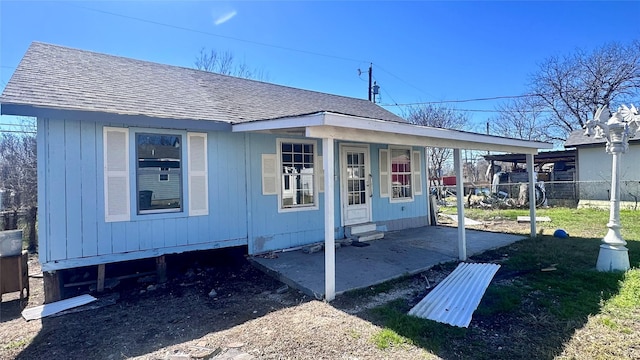 exterior space with entry steps, fence, and roof with shingles