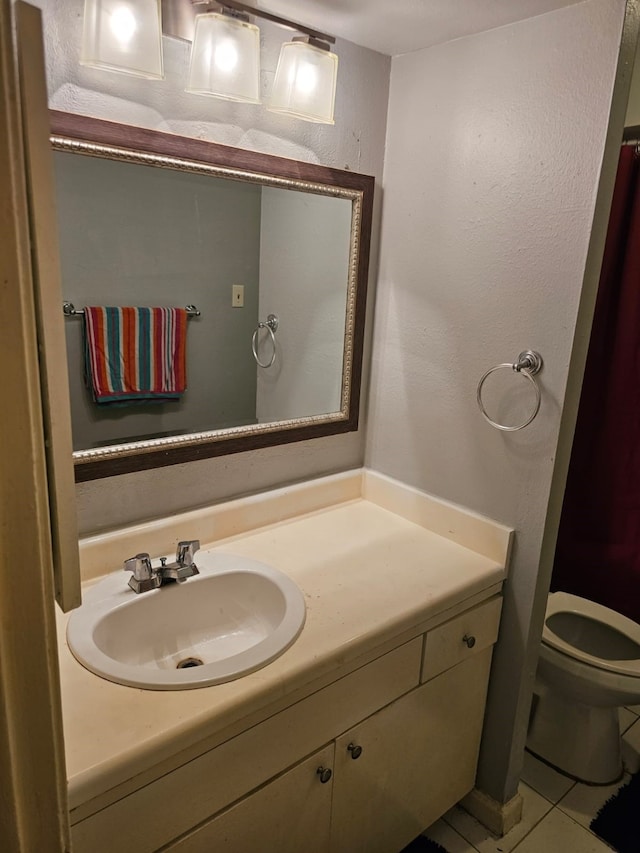 bathroom featuring toilet, tile flooring, and oversized vanity