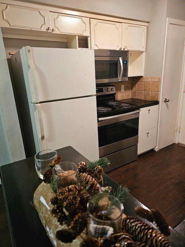 kitchen featuring dark hardwood / wood-style flooring, stainless steel appliances, tasteful backsplash, and white cabinetry