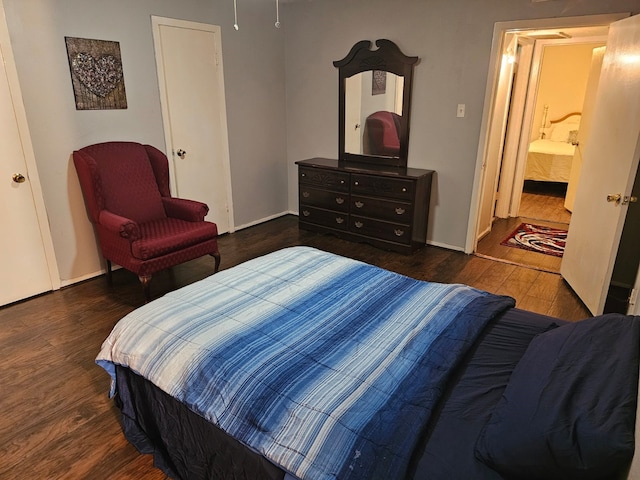 bedroom featuring dark wood-type flooring and connected bathroom