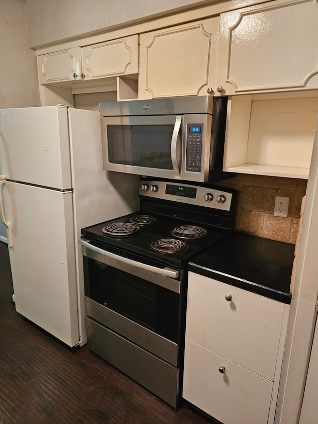 kitchen with dark hardwood / wood-style floors, white cabinetry, appliances with stainless steel finishes, and tasteful backsplash