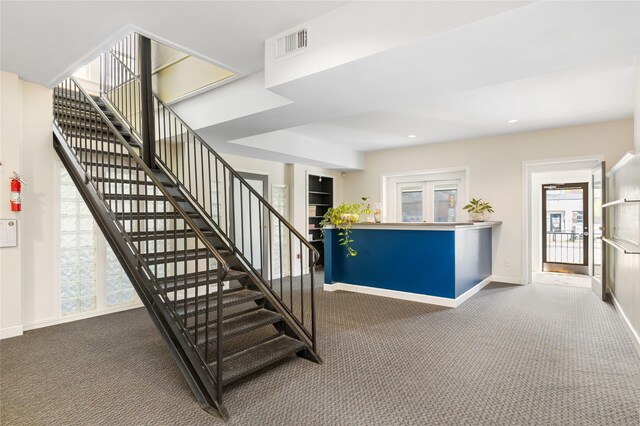 staircase featuring carpet flooring and plenty of natural light