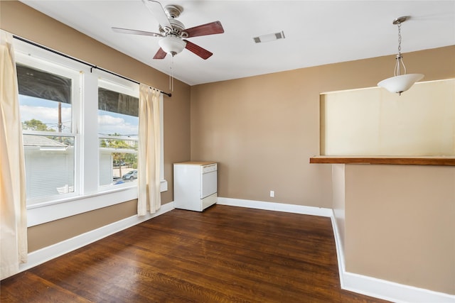 spare room with dark wood-style floors, baseboards, visible vents, and ceiling fan