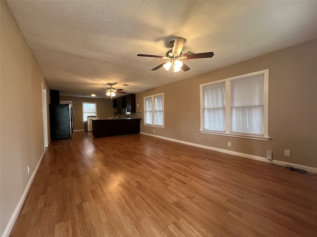 unfurnished living room with ceiling fan, a textured ceiling, and hardwood / wood-style floors