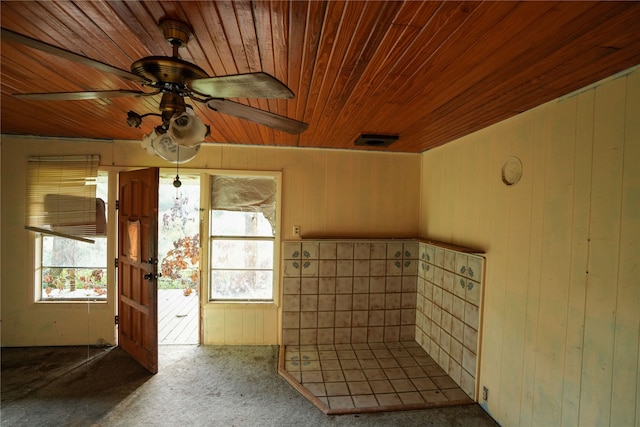 interior space featuring carpet flooring, ceiling fan, wooden ceiling, and wooden walls