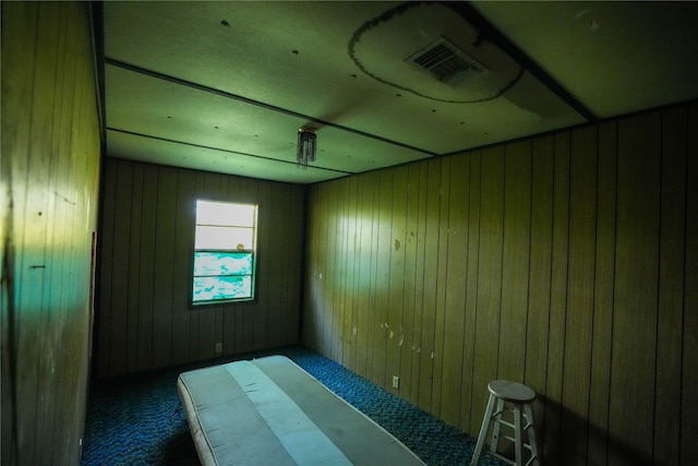 carpeted empty room with wooden walls