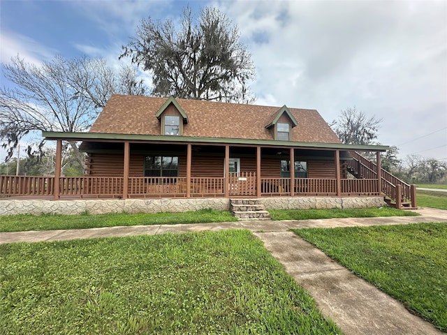 cabin with a porch and a front lawn