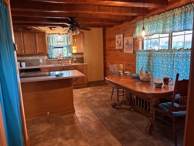 kitchen with dark tile patterned flooring, sink, hanging light fixtures, ceiling fan, and beam ceiling