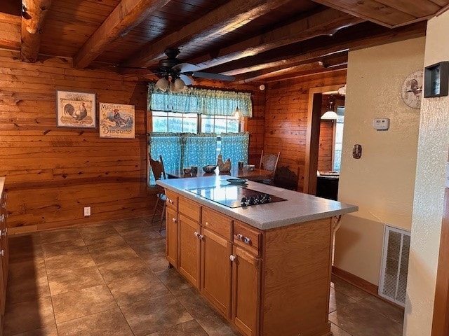 kitchen featuring wood walls, a kitchen island, wooden ceiling, and beam ceiling