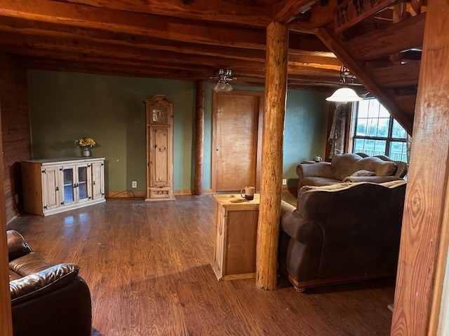 living room with ceiling fan, beamed ceiling, and hardwood / wood-style flooring