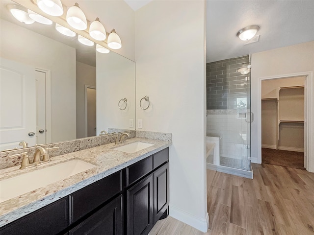 bathroom featuring wood-type flooring, an enclosed shower, and vanity