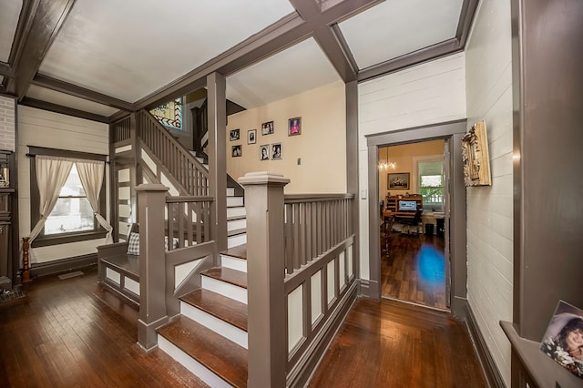 stairs with wood-type flooring, beamed ceiling, coffered ceiling, and wooden walls