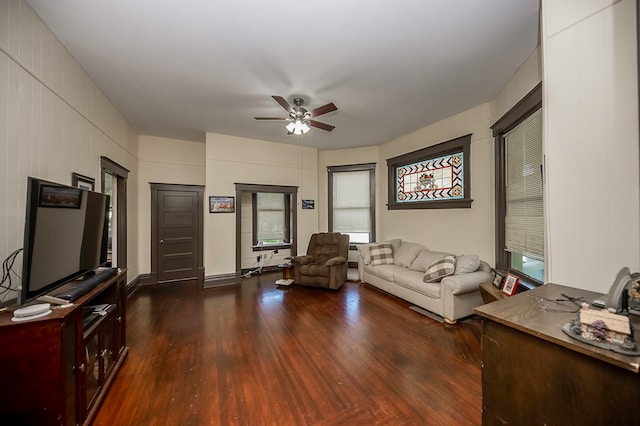 unfurnished living room featuring dark wood-type flooring and ceiling fan