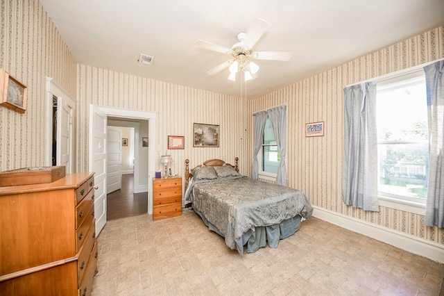 bedroom with ceiling fan and multiple windows