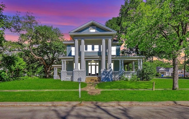 greek revival house featuring a yard and covered porch