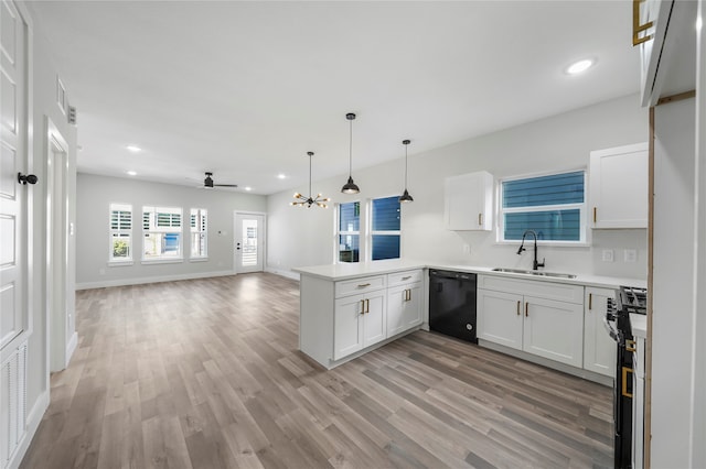 kitchen with kitchen peninsula, white cabinets, hanging light fixtures, dishwasher, and sink