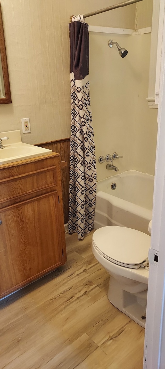 full bathroom featuring toilet, shower / bath combination with curtain, vanity, and hardwood / wood-style floors