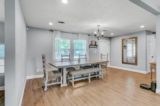 dining space with a chandelier and light hardwood / wood-style flooring