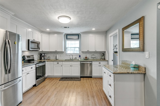 kitchen featuring white cabinetry, appliances with stainless steel finishes, and light wood-type flooring