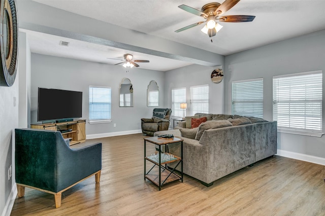 living room with plenty of natural light, ceiling fan, and light hardwood / wood-style flooring