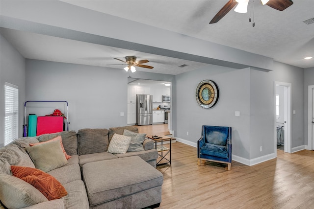 living room with light hardwood / wood-style flooring and ceiling fan