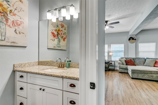 bathroom featuring a textured ceiling, hardwood / wood-style floors, ceiling fan, and oversized vanity