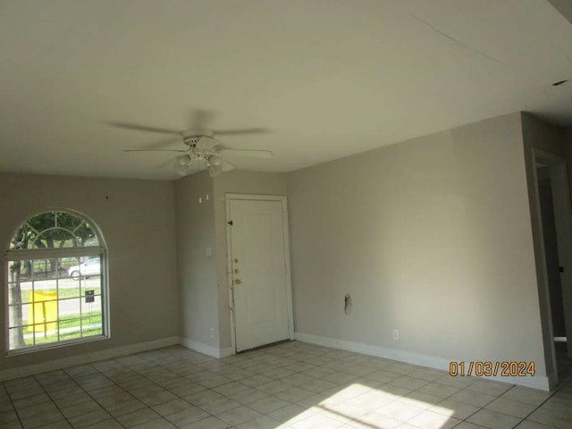 spare room with ceiling fan and light tile flooring