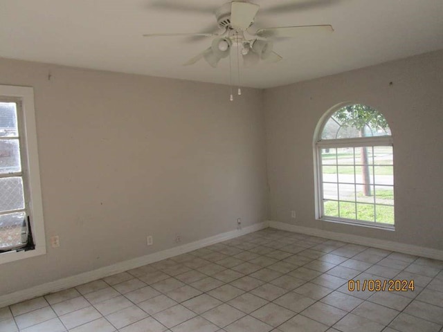 unfurnished room with ceiling fan, a wealth of natural light, and light tile floors