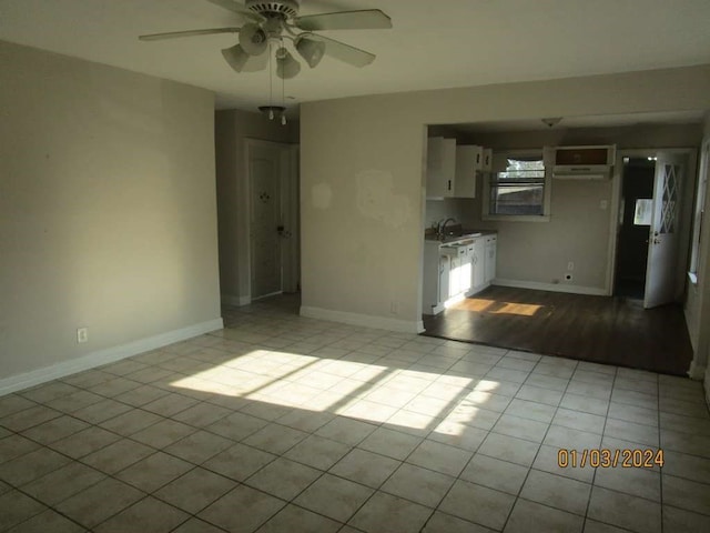 empty room with ceiling fan, light hardwood / wood-style flooring, and sink