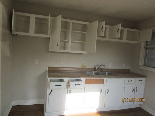 kitchen with dark hardwood / wood-style floors, white cabinets, and sink