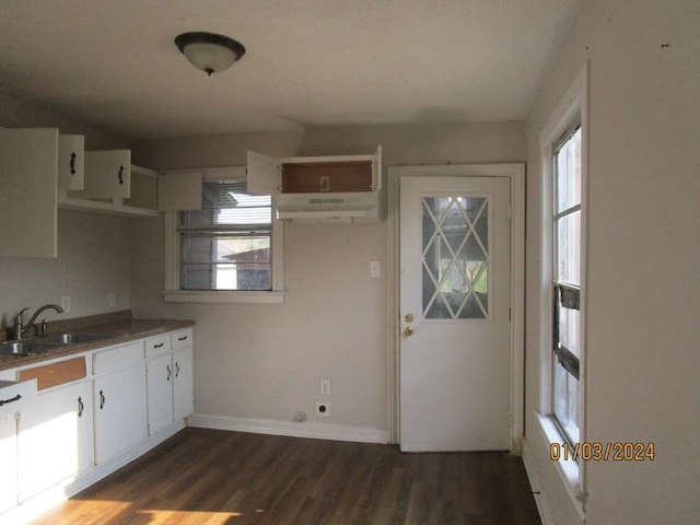 kitchen featuring dark hardwood / wood-style floors, white cabinets, an AC wall unit, and sink