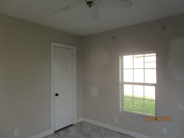 tiled spare room featuring ceiling fan