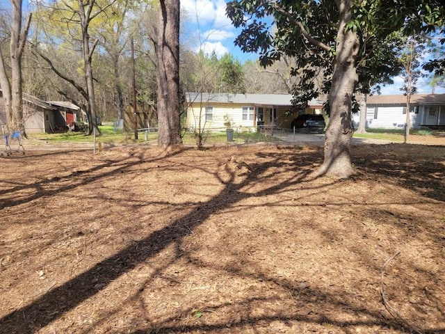 view of yard featuring a carport and a shed