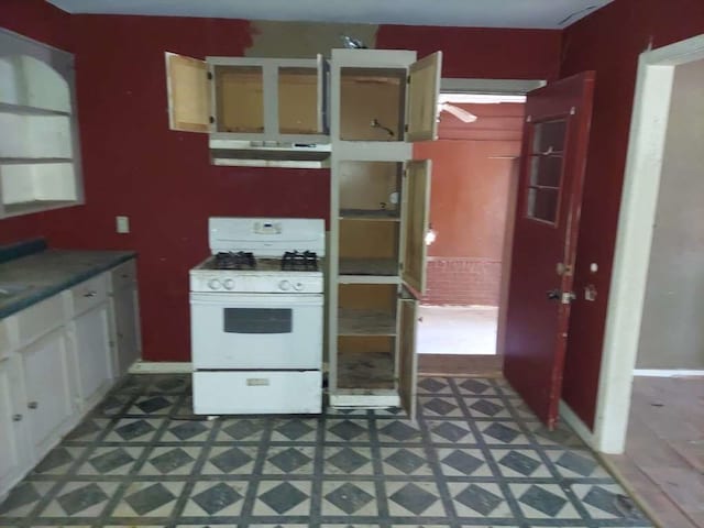 kitchen with dark tile flooring and gas range gas stove