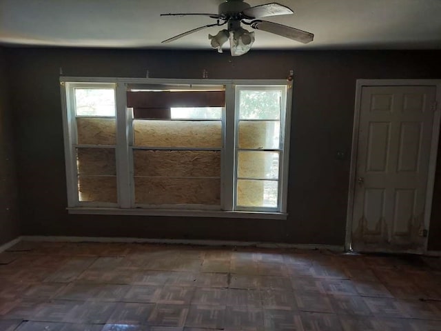 unfurnished room featuring dark parquet flooring and ceiling fan