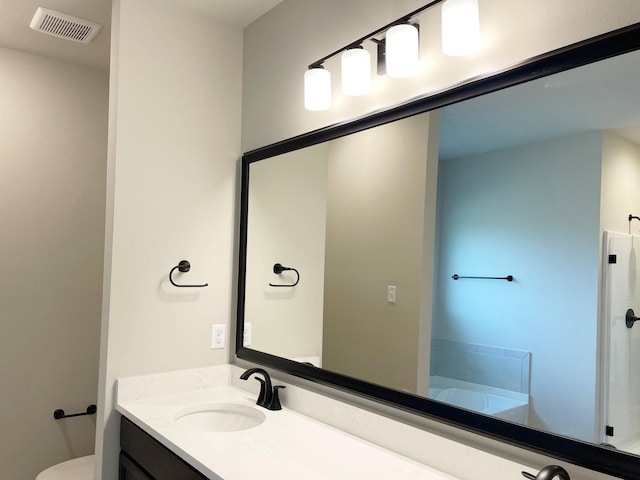 bathroom with a tub to relax in, vanity, and toilet