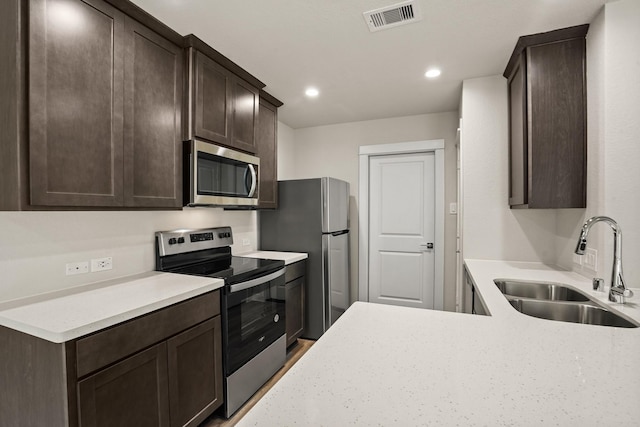 kitchen featuring sink, dark brown cabinets, and stainless steel appliances