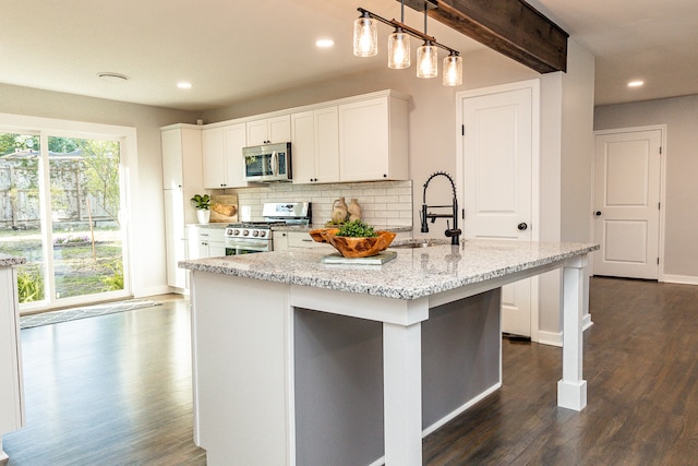 kitchen featuring decorative light fixtures, dark hardwood / wood-style floors, white cabinetry, and stainless steel appliances