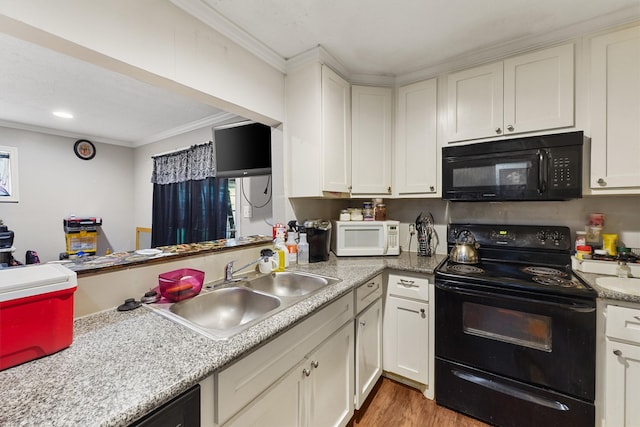 kitchen with white cabinets, ornamental molding, light hardwood / wood-style floors, and black appliances