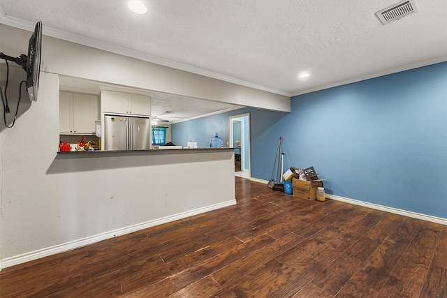 interior space with dark hardwood / wood-style flooring, a textured ceiling, and stainless steel fridge