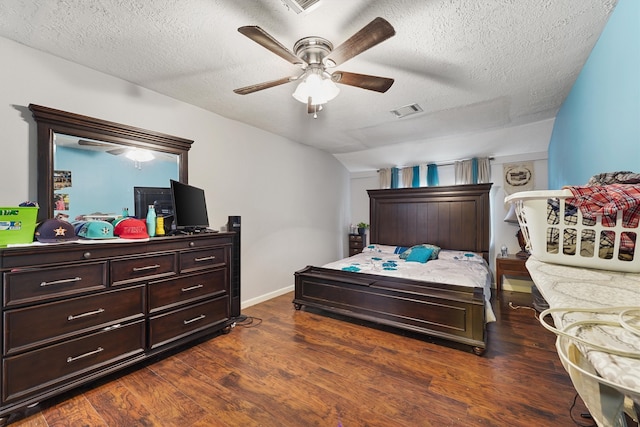 bedroom with dark hardwood / wood-style floors, a textured ceiling, and ceiling fan