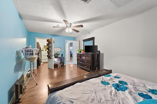 bedroom with ceiling fan, a textured ceiling, and hardwood / wood-style flooring