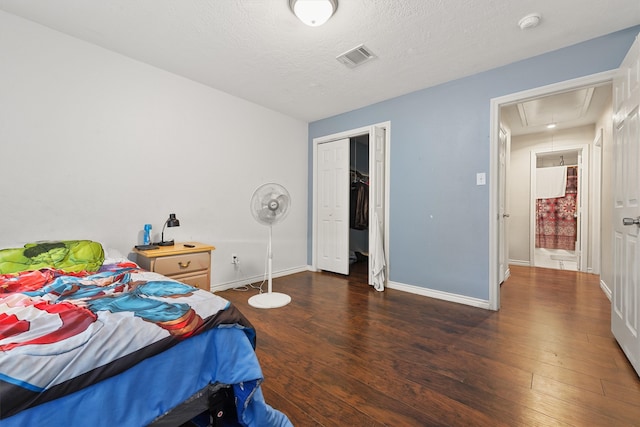 bedroom featuring dark hardwood / wood-style floors, a textured ceiling, and a closet