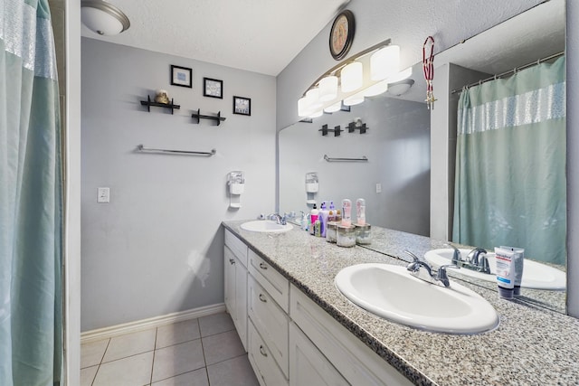 bathroom featuring double sink, a textured ceiling, large vanity, and tile floors