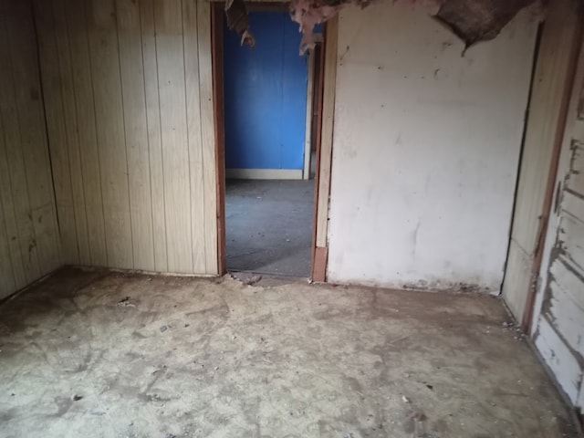 unfurnished room featuring wood walls