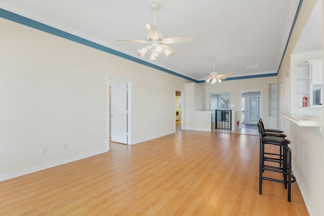 living room with ceiling fan, light wood-type flooring, crown molding, and french doors