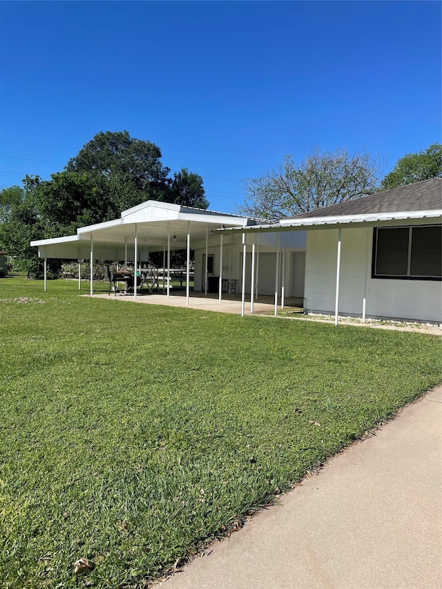 back of house featuring a lawn and a carport