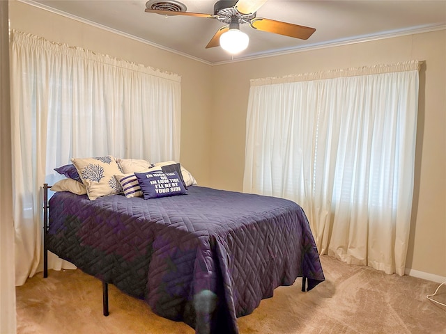 carpeted bedroom featuring ceiling fan and crown molding