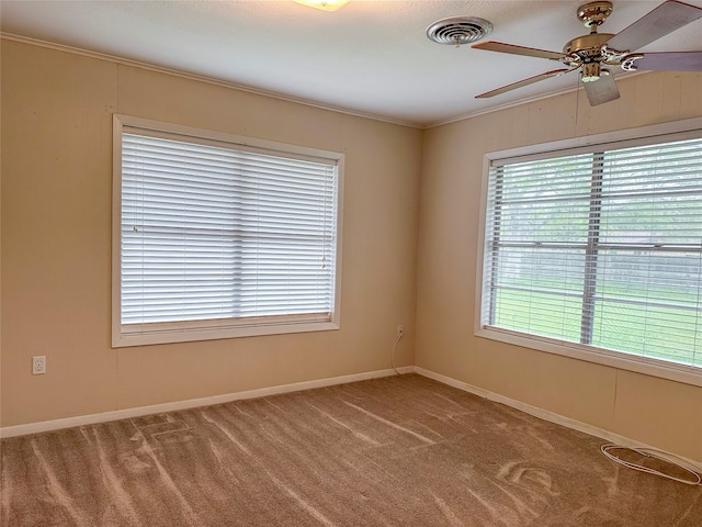 empty room featuring plenty of natural light, ornamental molding, carpet flooring, and ceiling fan